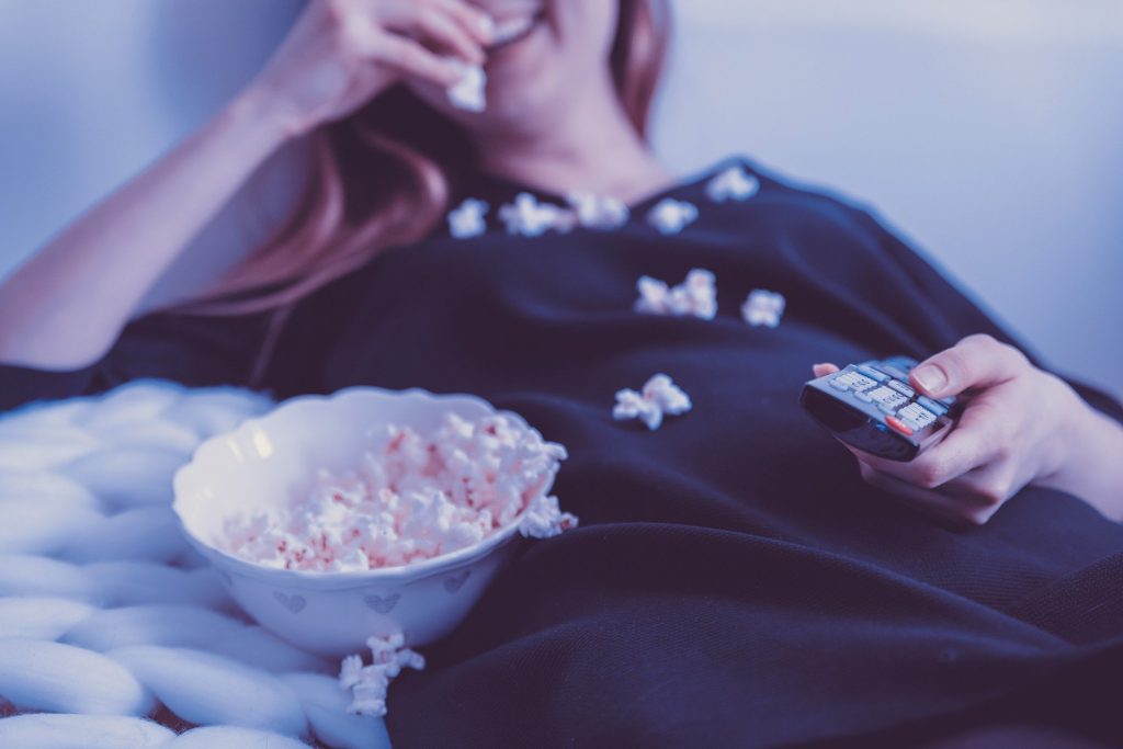 lady watching TV with popcorn